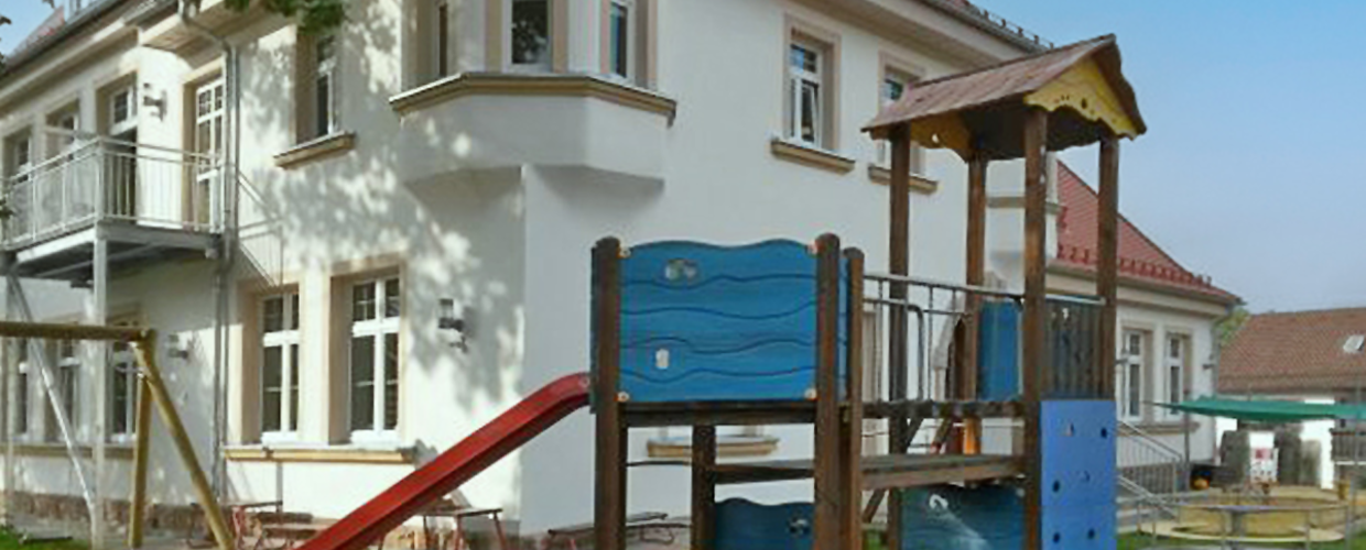 Kindertagesstätte Alte Mangersreuther Schule in Kulmbach, Außenansicht mit Spielgerät